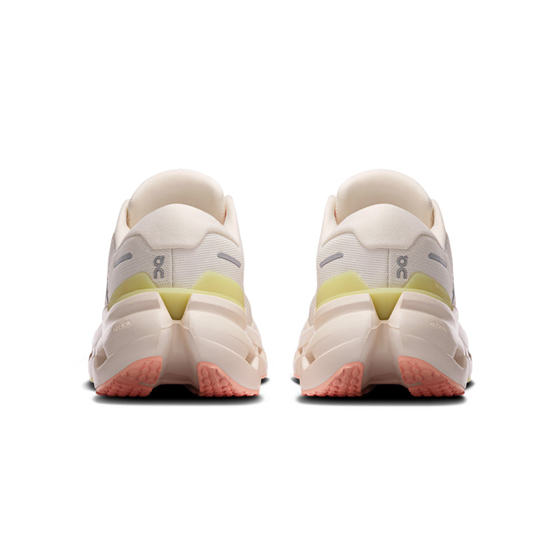 Women's running shoes rear view showing chunky midsole, yellow-green heel tab, and coral outsole