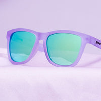 Purple translucent sunglasses with teal mirrored lenses on gradient purple background