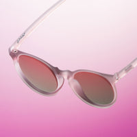 Clear pink sunglasses with rose gradient lenses on pink ombre background