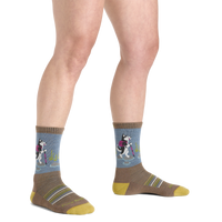 On-model view of crew socks with hiking husky dog pattern on blue cuff and taupe body