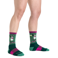 Crew-length novelty socks with raccoon camping pattern, green and magenta colorway, on-model view
