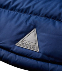 Close-up detail of quilted down jacket showing silver triangular brand logo patch