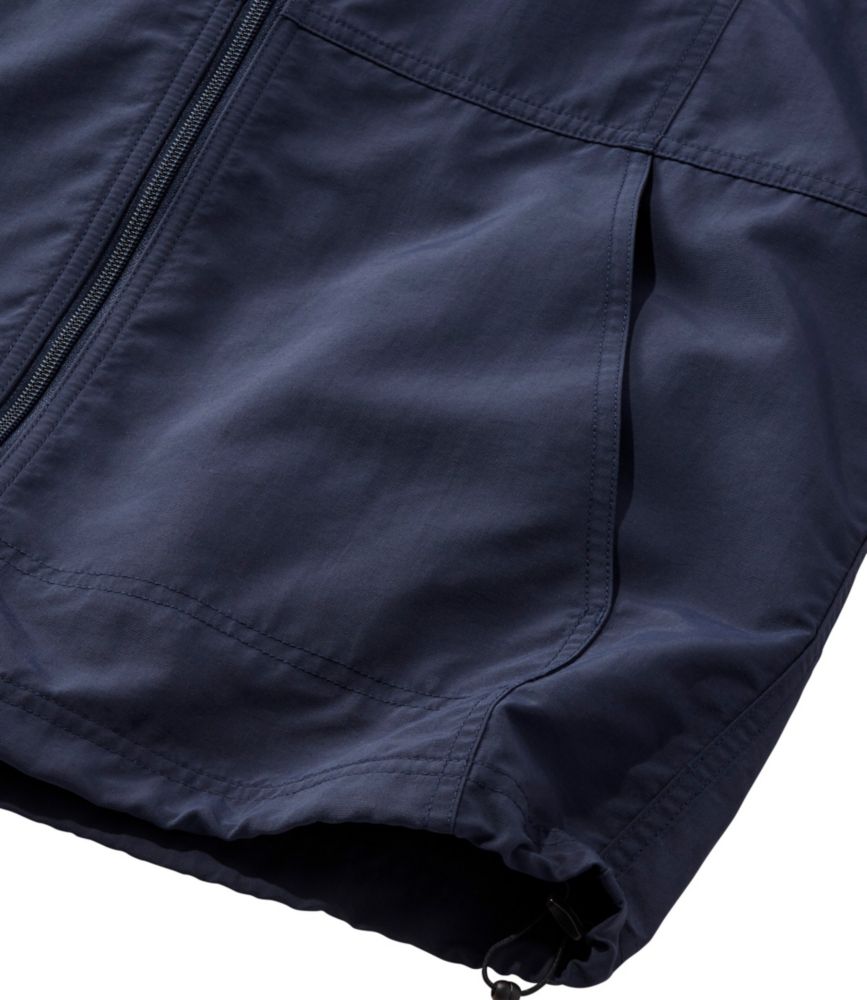 Close-up of dark navy zip-up jacket hem with side pocket and drawcord adjustment