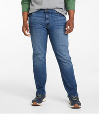 Men's straight leg athletic fit jeans in medium dark blue wash, front view with sneakers
