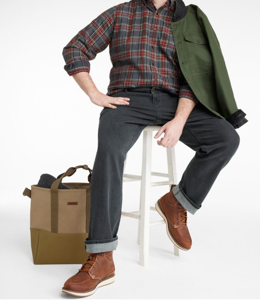 Men's straight leg jeans in dark charcoal, cuffed at ankle, worn seated on stool