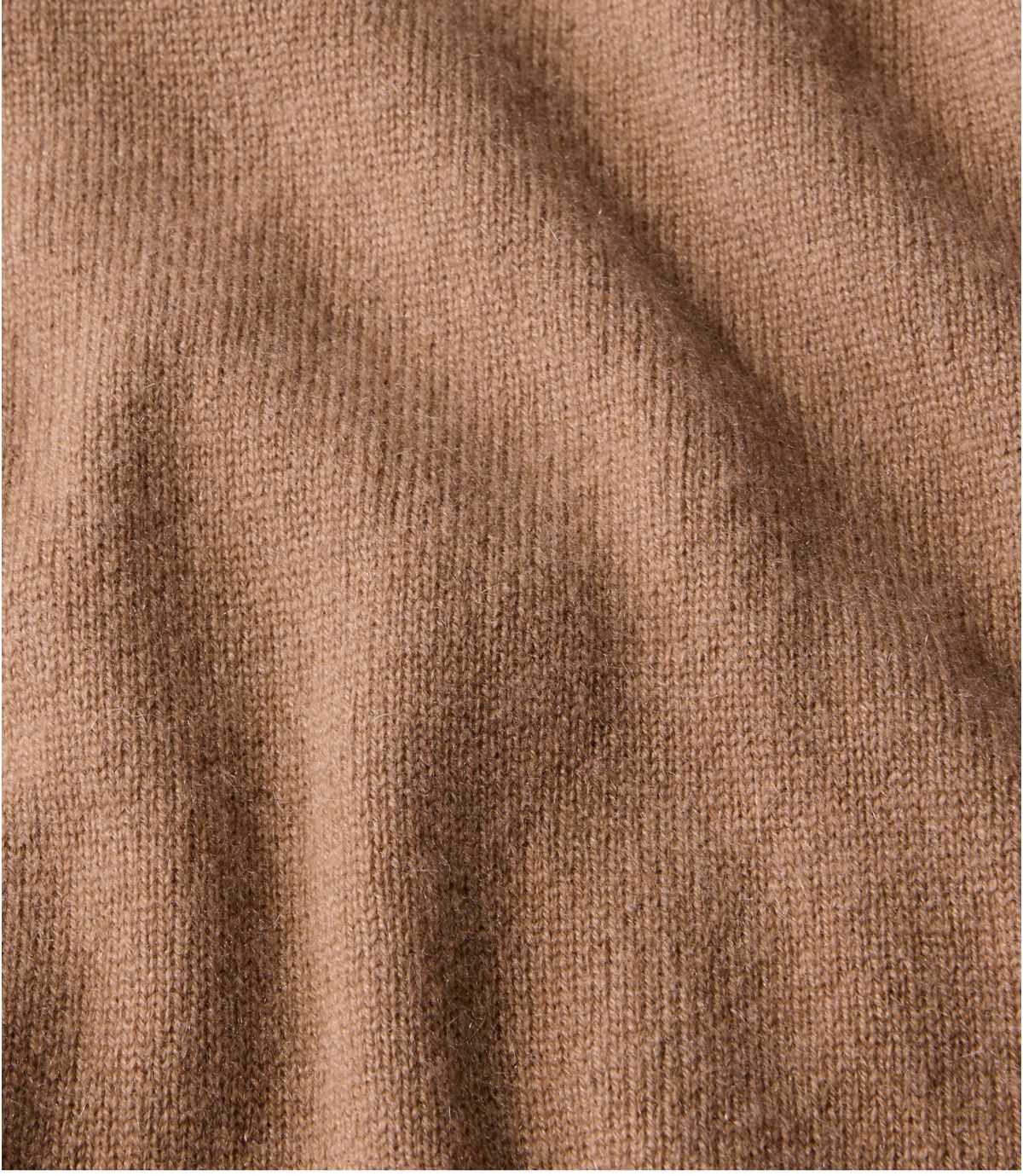 Close-up detail of a fine knit cashmere sweater in warm camel heather, showing texture and drape