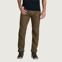 Men's olive brown canvas pants with flannel lining cuff, front view, styled with hiking boots