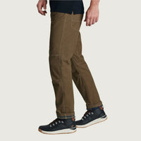 Men's rugged work pants in olive brown with articulated knees, side view, worn with hiking boots