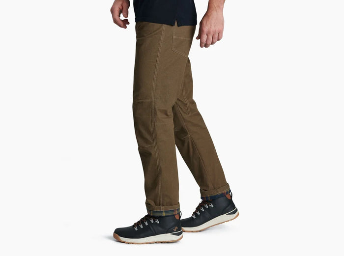 Men's rugged work pants in olive brown with contrast stitching, side view, with hiking boots