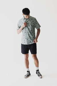 Light green short-sleeve button-up shirt with bicycle print pattern worn by male model