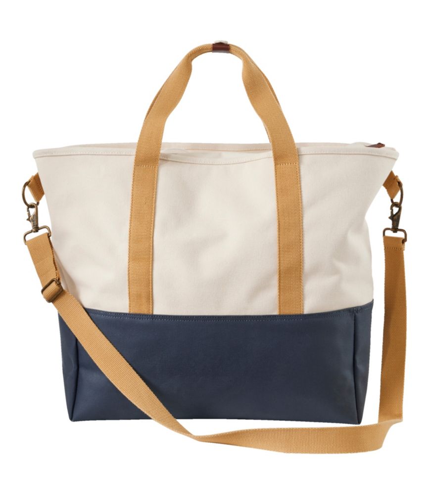 Two-tone canvas tote bag with cream upper, navy lower section, and tan straps