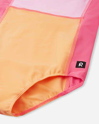 Orange-pink gradient one-piece swimsuit detail showing fabric texture and seam construction
