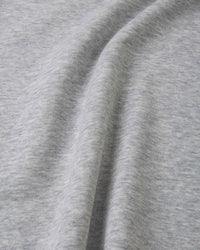 Light grey melange sweatshirt fabric close-up showing soft knit texture and seam detail