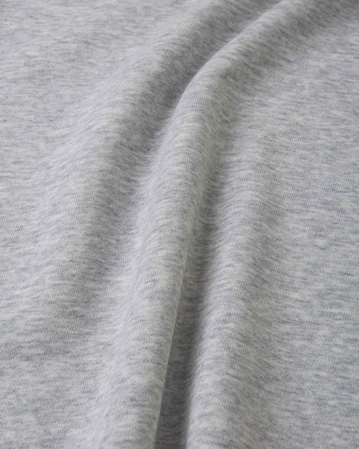 Light grey melange sweatshirt fabric close-up showing soft knit texture and seam detail