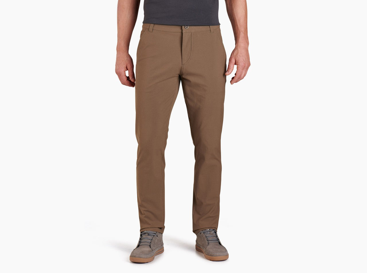 Men's slim-fit chino pants in warm brown, front view, paired with casual sneakers