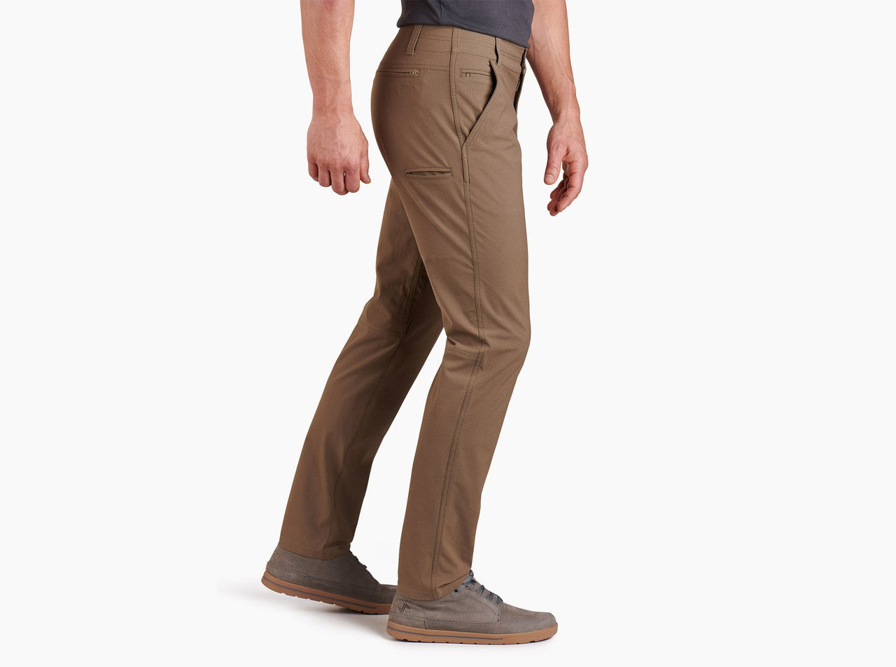 Men's slim-fit chino pants in warm brown, side view, worn with casual shoes