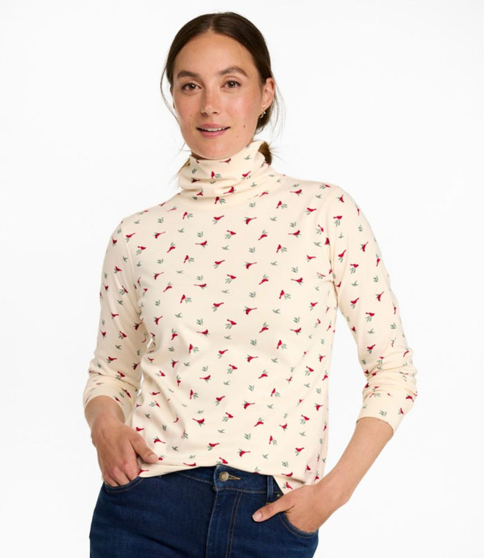Women's long-sleeve turtleneck top in cream with red cardinal bird print, front view on model