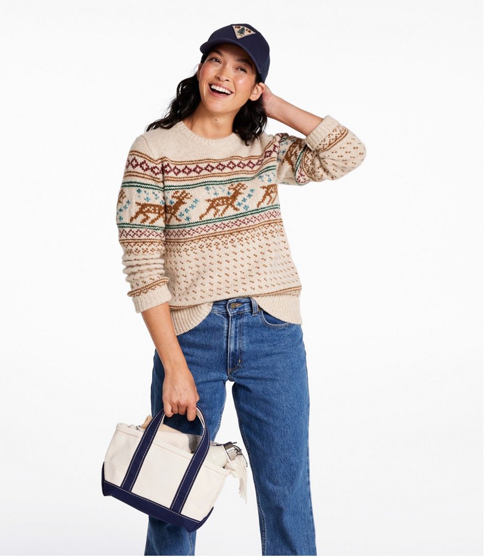 Small canvas tote bag with navy blue handles and trim, held by model