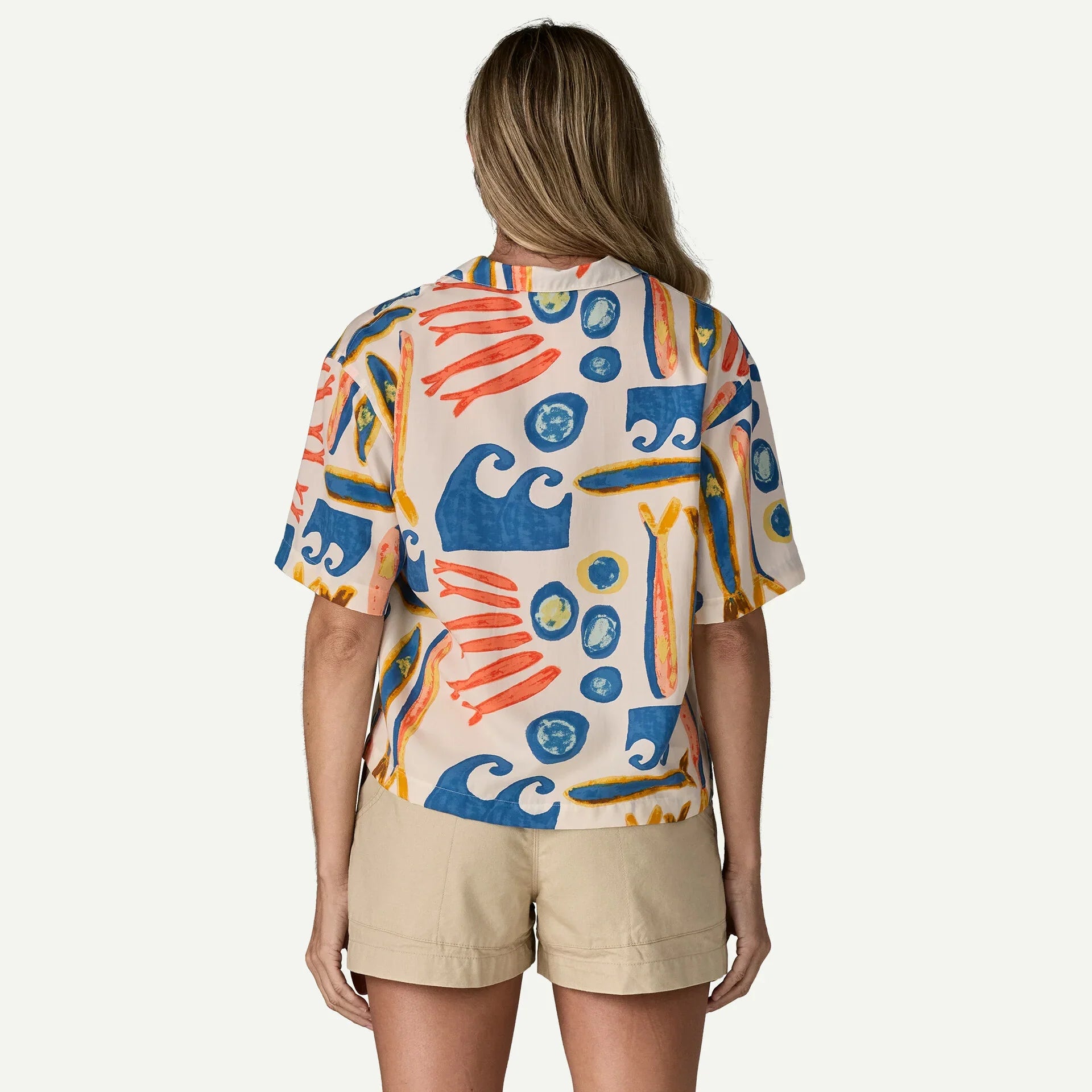 Short-sleeve shirt with colorful abstract print worn with khaki shorts, back view
