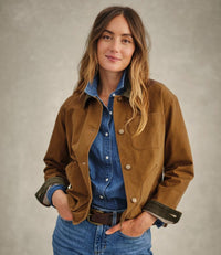 Brown canvas field jacket with snap buttons worn over denim shirt