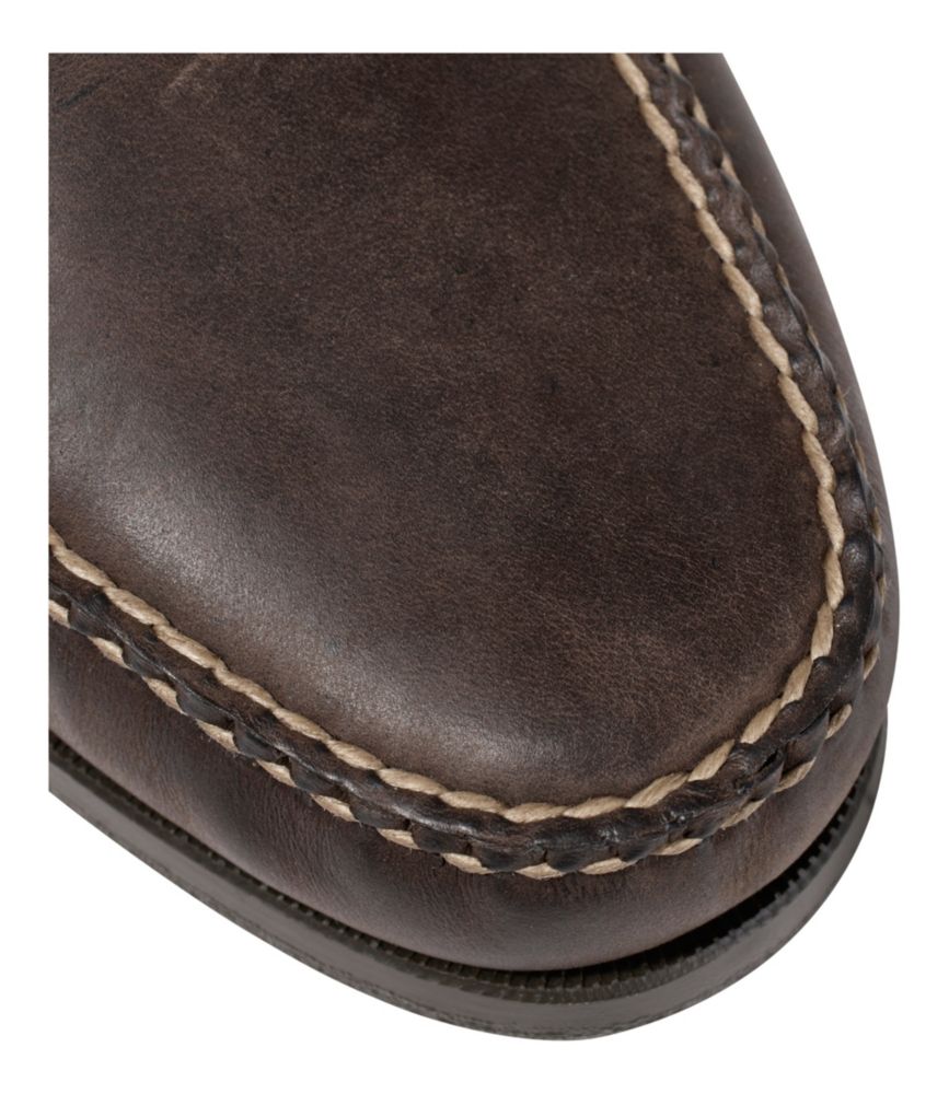 Close-up of moccasin toe stitching detail on dark brown leather loafer shoe