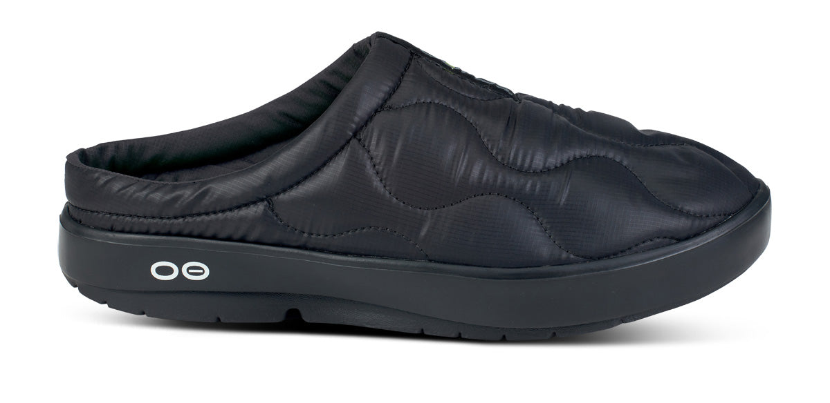 Black quilted slip-on mule with open back and cushioned platform sole, side view