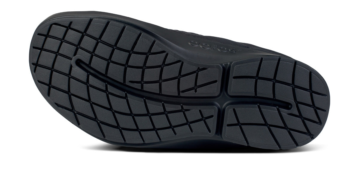 Bottom sole view of a mule shoe showing textured grip pattern and arch support