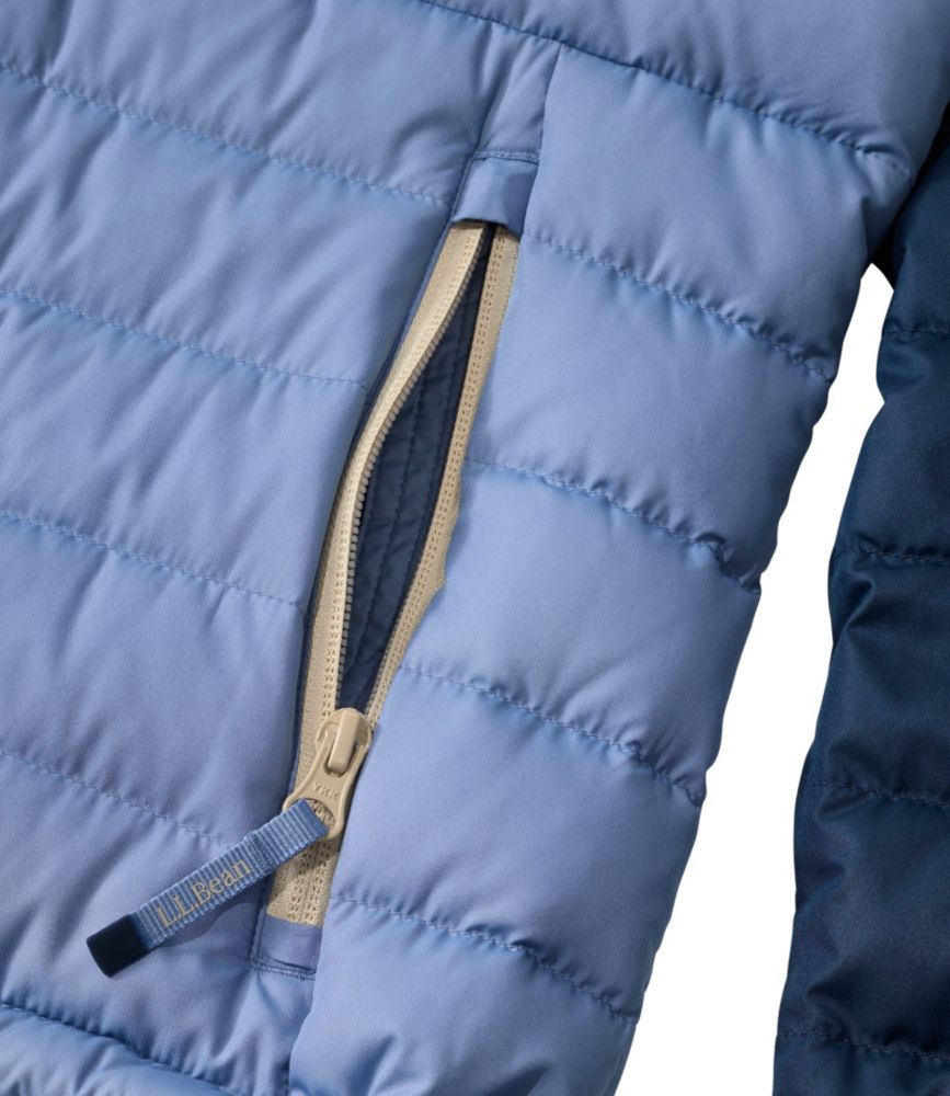 Close-up detail of quilted puffer jacket pocket with tan zipper pull tab