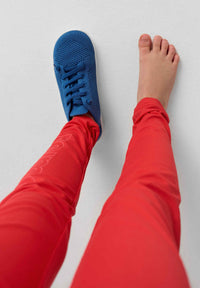 Blue knit barefoot shoes worn on feet, showing breathable mesh upper and minimal design