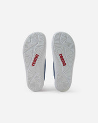 Bottom view of navy blue children's barefoot shoes showing white textured outsoles
