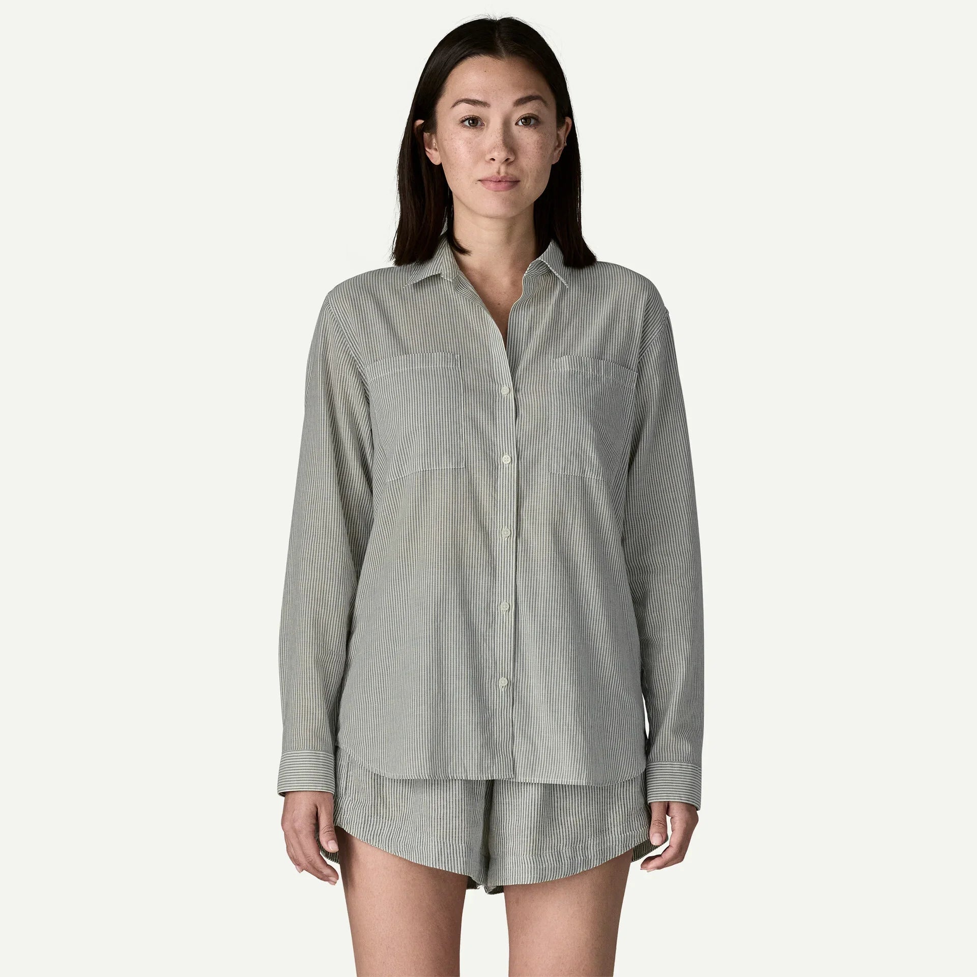 Gray pinstriped button-down shirt and shorts set worn by woman on white background