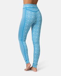Women's high waist base layer leggings with Nordic snowflake pattern, back view, barefoot model
