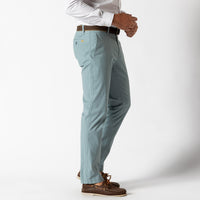 Light blue chino pants shown from side angle with white dress shirt and boat shoes