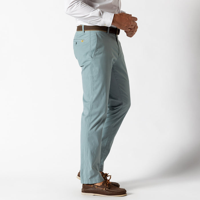 Light blue chino pants shown from side angle with white dress shirt and boat shoes