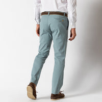 Light blue chino pants worn with white shirt and brown belt, rear three-quarter view