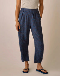 Navy blue patterned linen pants with elastic waistband and relaxed fit, worn with flip-flops