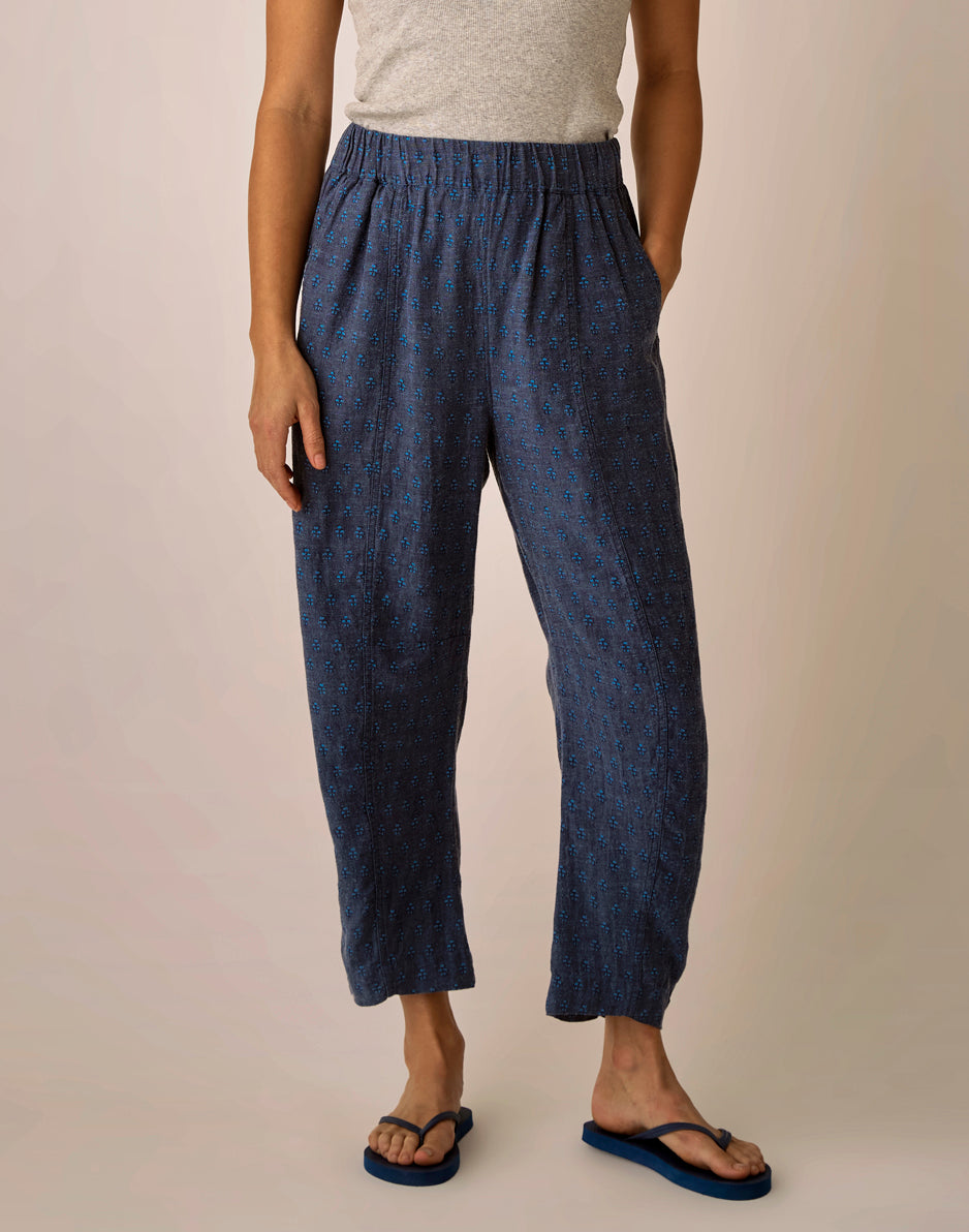 Navy blue patterned linen pants with elastic waistband and relaxed fit, worn with flip-flops