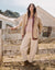 Women's oversized boucle coat in warm sandy beige, worn open over layered outfit, front view