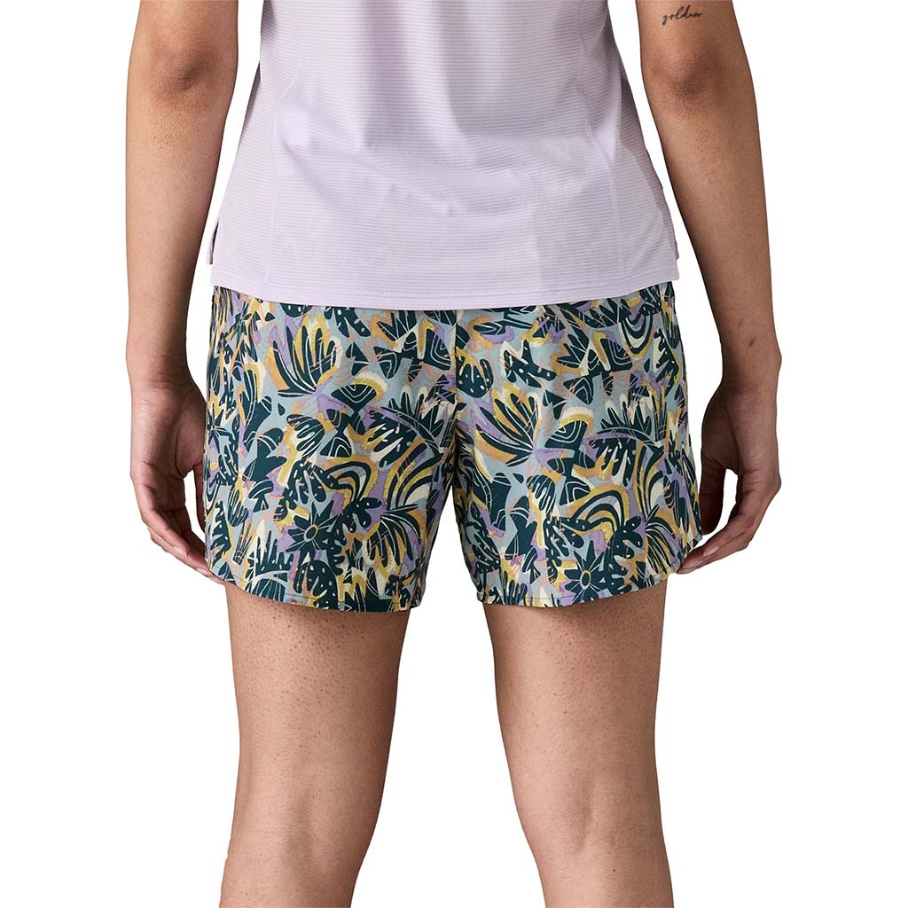 Women's athletic shorts with tropical leaf print pattern, back view showing fit and length
