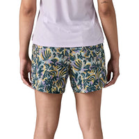 Women's athletic shorts with tropical leaf print pattern, back view showing fit and length