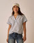 Light blue pinstriped short-sleeve button-up top with collar worn with jeans