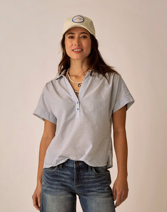 Light blue pinstriped short-sleeve button-up top with collar worn with jeans