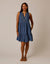 Sleeveless tiered mini dress with v-neck and small polka dot pattern, styled with necklace