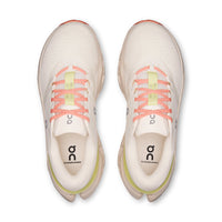 Top-down view of a pair of cream running shoes with coral laces and lime green midsole
