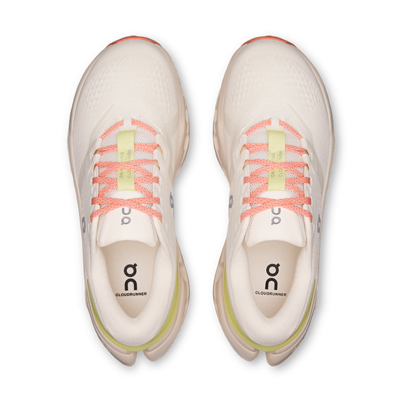 Top-down view of a pair of cream running shoes with coral laces and lime green midsole