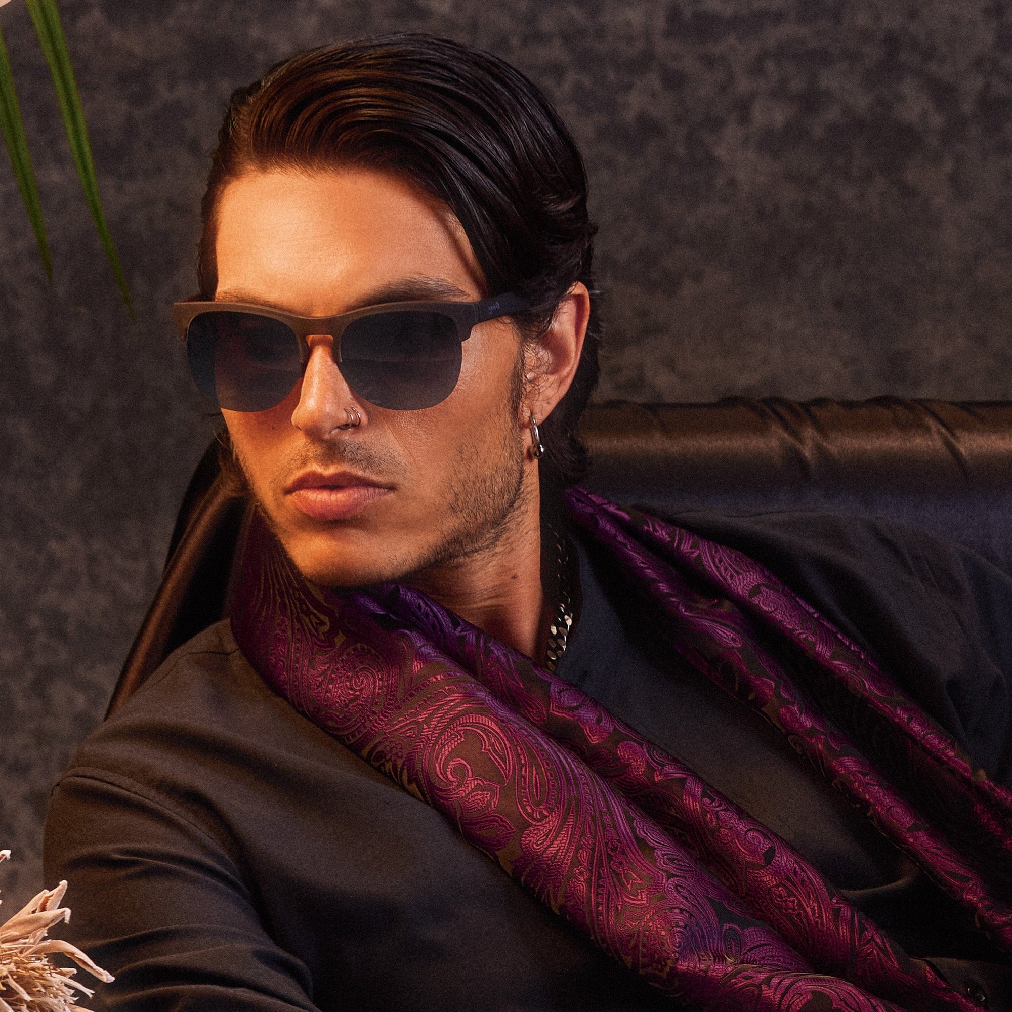 Brown tortoiseshell sunglasses with dark gradient lenses worn by man in purple shirt