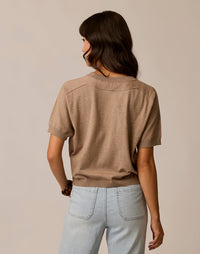 Women's short-sleeve knit sweater tee in tan, back view, paired with light wash jeans