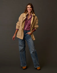Women's boucle fleece coat in warm tan, open front with patch pockets, worn over floral shirt