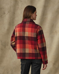 Women's plaid wool jacket in red and burgundy check, back view on model with dark jeans