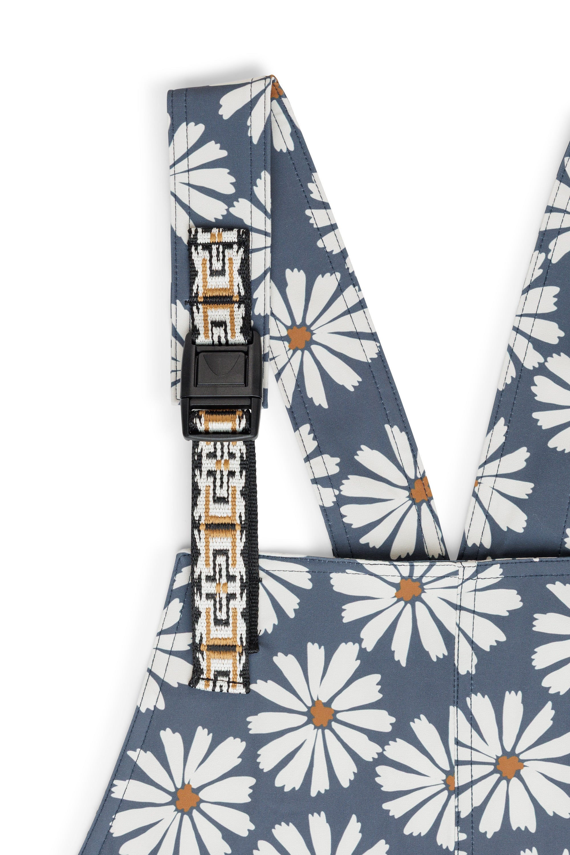 Women's overalls with white daisy pattern on blue background, adjustable shoulder straps visible